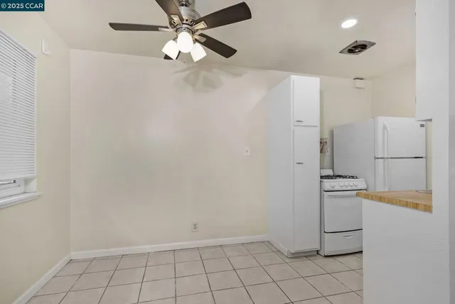 a view of a refrigerator in kitchen and white cabinets