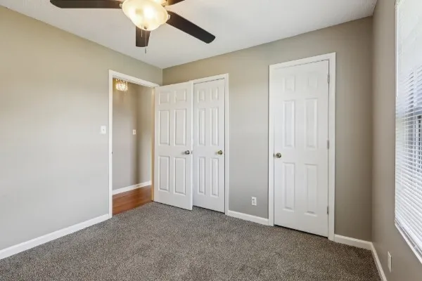 an empty room with a ceiling fan and a window