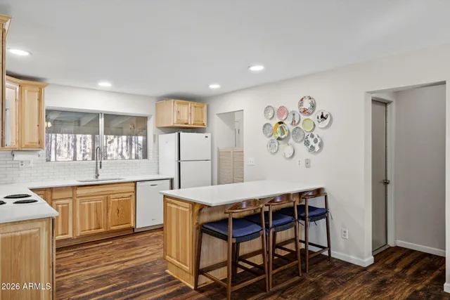 a bathroom with a sink a mirror and a painting on the wall