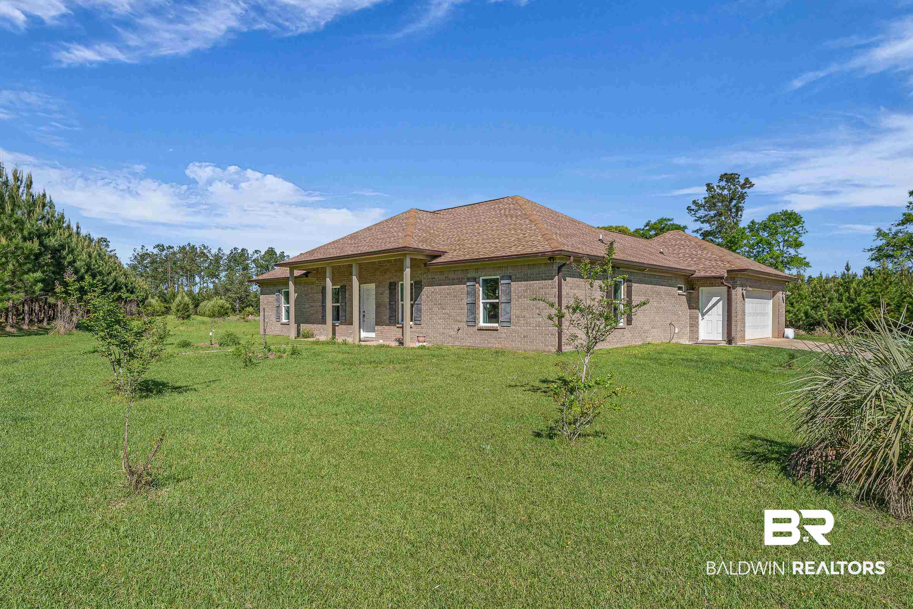 18255 Cactus Court Elberta, AL 36530 - Photo 3 of 53 View of side of home featuring a lawn, a patio area, brick siding, and a garage