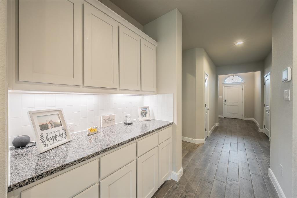 1212 Bosque Lane Weatherford, TX 76087 - Photo 5 of 38 a kitchen with granite countertop white cabinets and sink