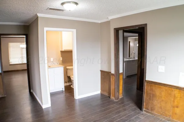 a view of a hallway with wooden floor and a livingroom