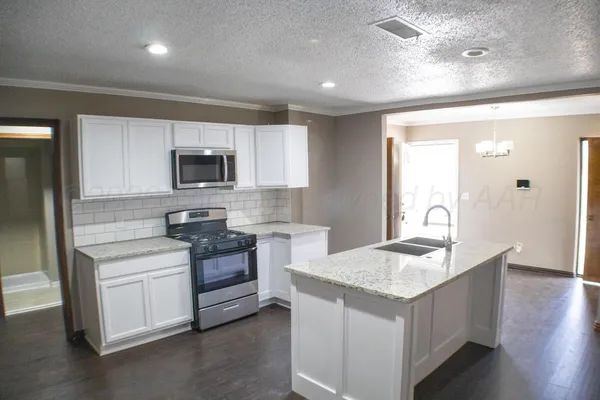 a kitchen with a sink stove and refrigerator