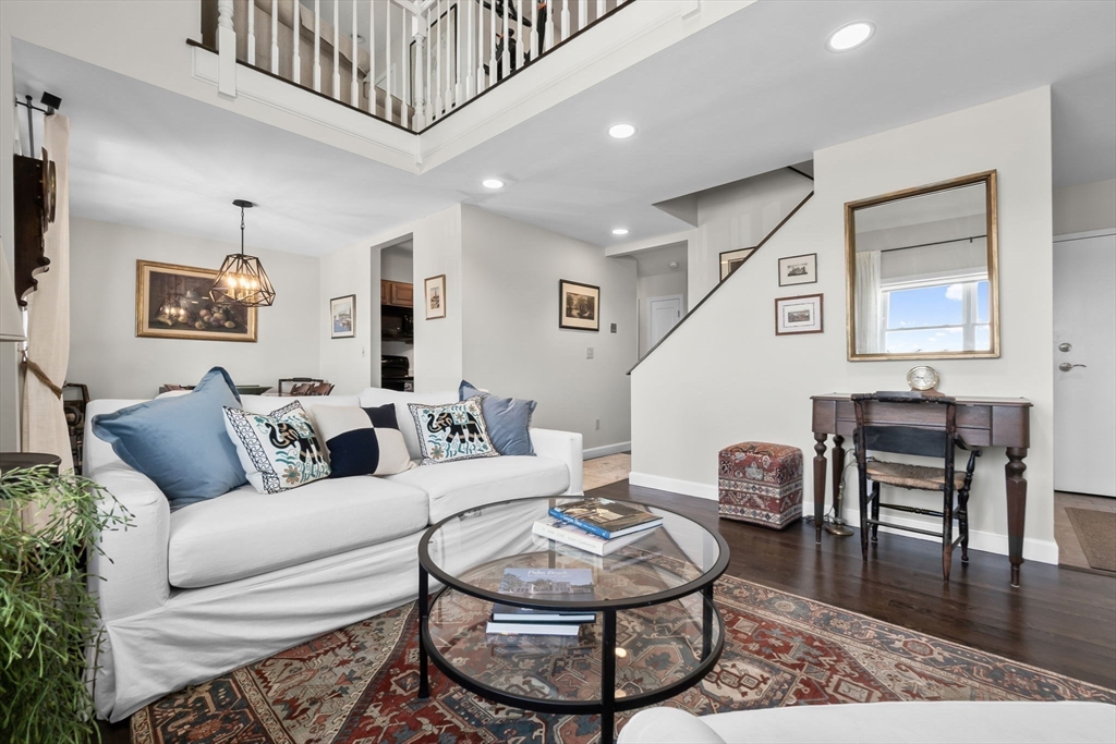 117 Water Street, Unit 28 Beverly, MA 01915 - Photo 4 of 35 a living room with furniture a wooden floor and a chandelier