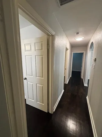 a view of a hallway with wooden floor