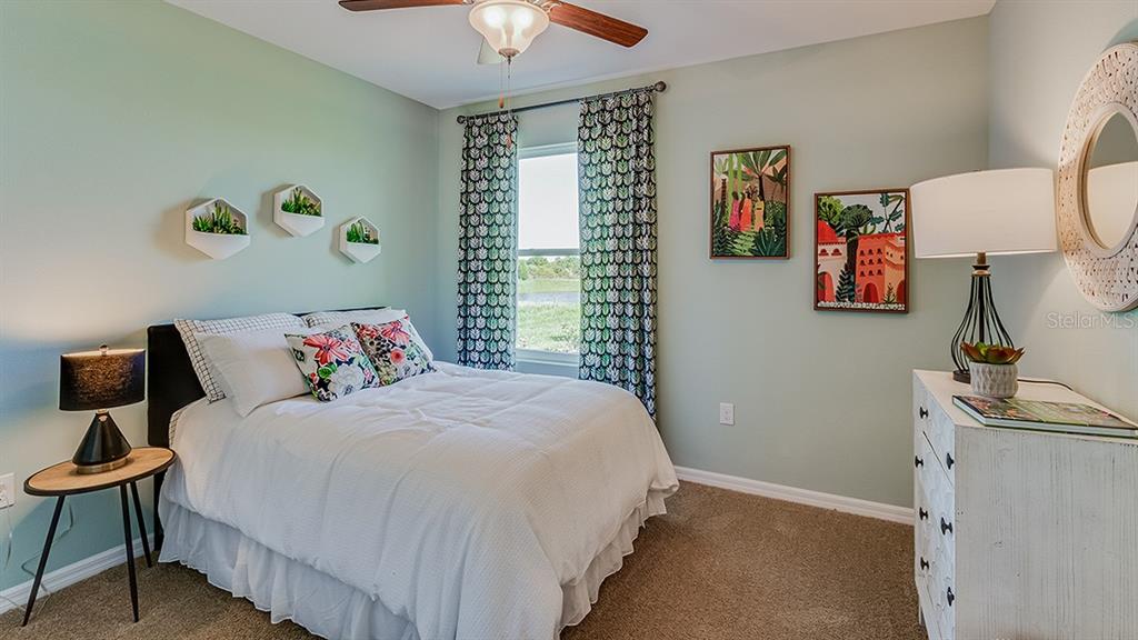 18118 Wheathouse Place Lakewood Ranch, FL 34211 - Photo 11 of 41 a bedroom with a bed and a chandelier