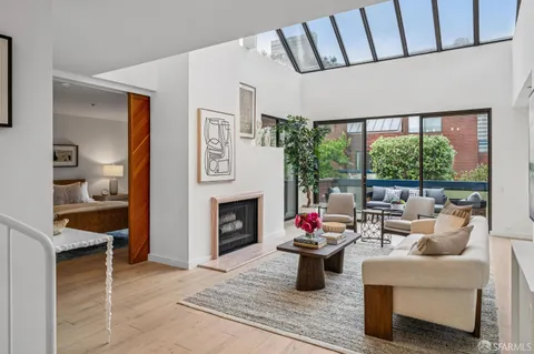 a living room with furniture a fireplace and a potted plant