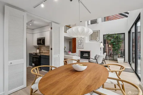 a view of a dining room with furniture a chandelier and wooden floor