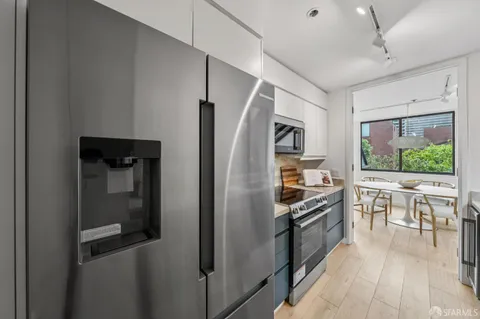 a kitchen with stainless steel appliances granite countertop a refrigerator and a stove