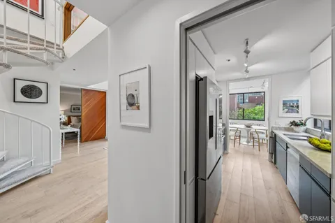 a view of a hallway with furniture and wooden floor