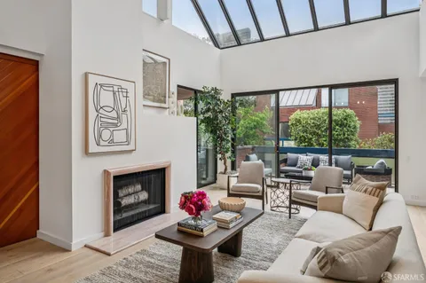 a living room with furniture a large window and a fireplace
