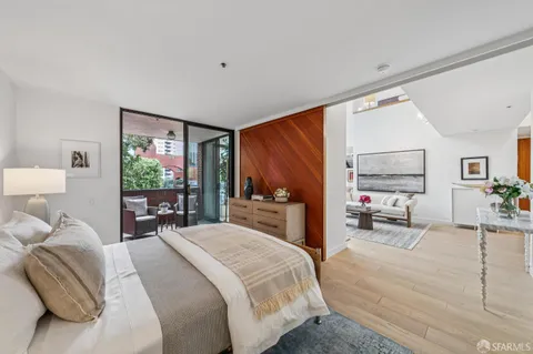a bedroom with a bed and large windows