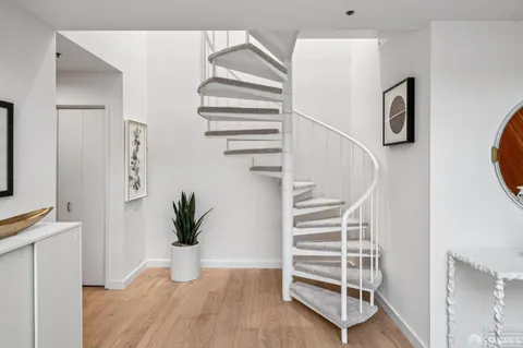 a view of staircase with lots of frames on wall and a window
