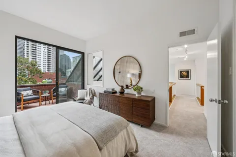 a bedroom with a bed and large windows