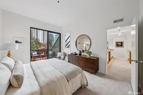 a bedroom with a bed and dresser with mirror