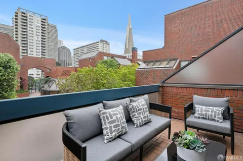 a roof deck with couch and a potted plant