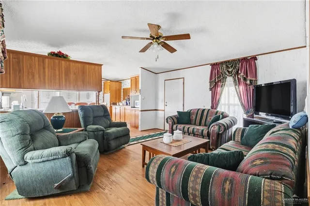a living room with furniture ceiling fan and a window
