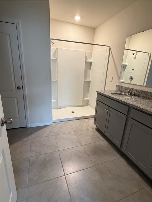 569 Talisi Loop St. Cloud, FL 34771 - Photo 13 of 20 a bathroom with a sink a mirror and a shower