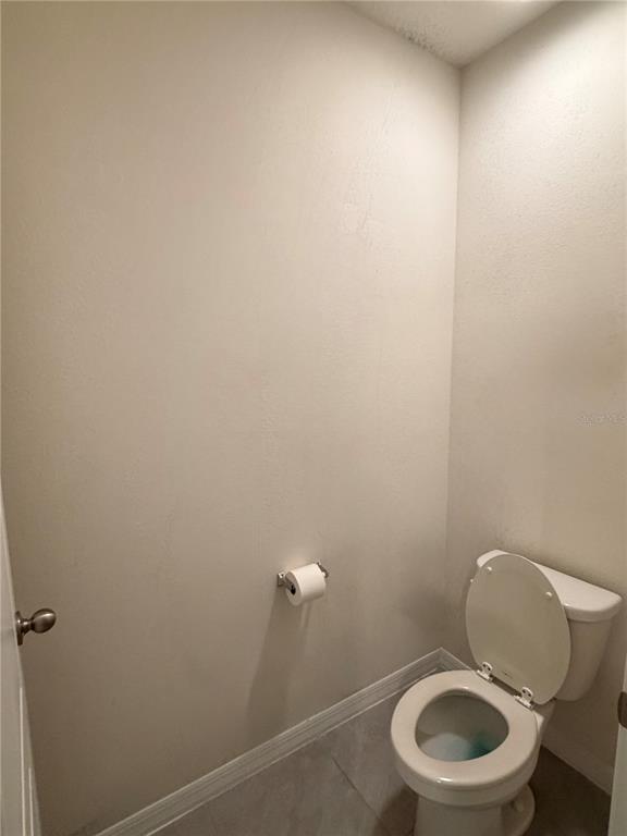 569 Talisi Loop St. Cloud, FL 34771 - Photo 14 of 20 a white toilet sitting next to a white sink and vanity