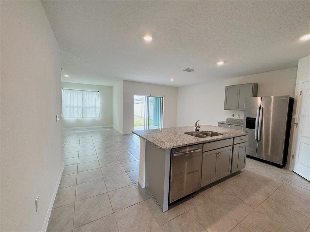 569 Talisi Loop St. Cloud, FL 34771 - Photo 4 of 20 a kitchen with stainless steel appliances granite countertop a stove and a refrigerator