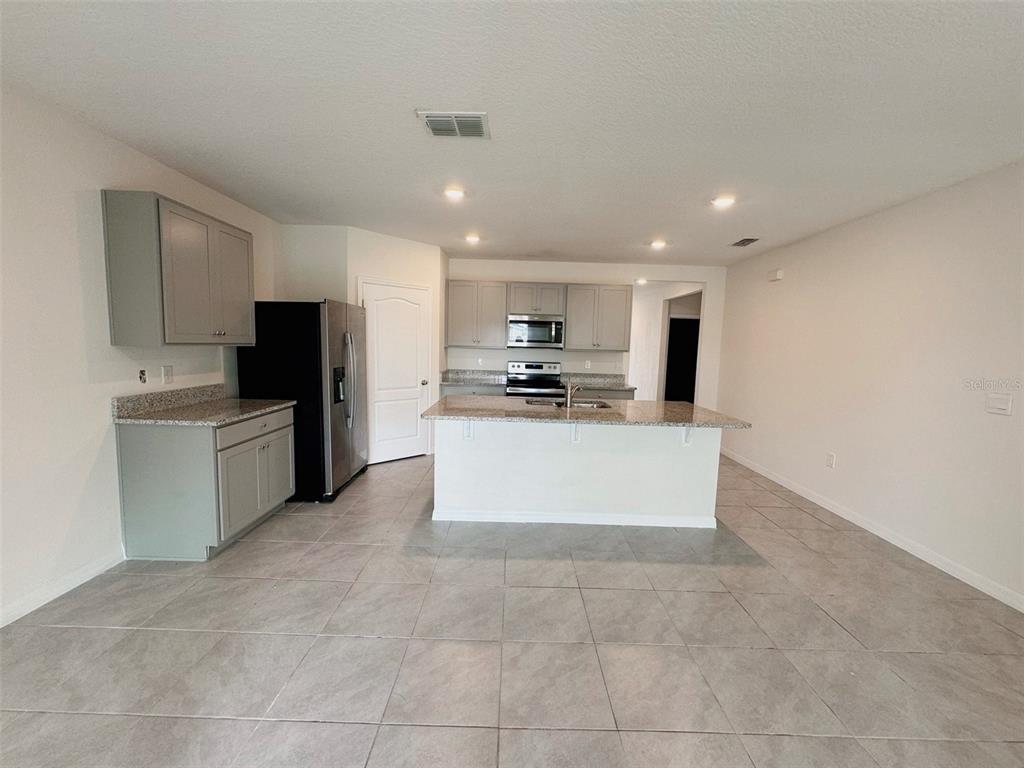 569 Talisi Loop St. Cloud, FL 34771 - Photo 6 of 20 a large kitchen with cabinets and stainless steel appliances