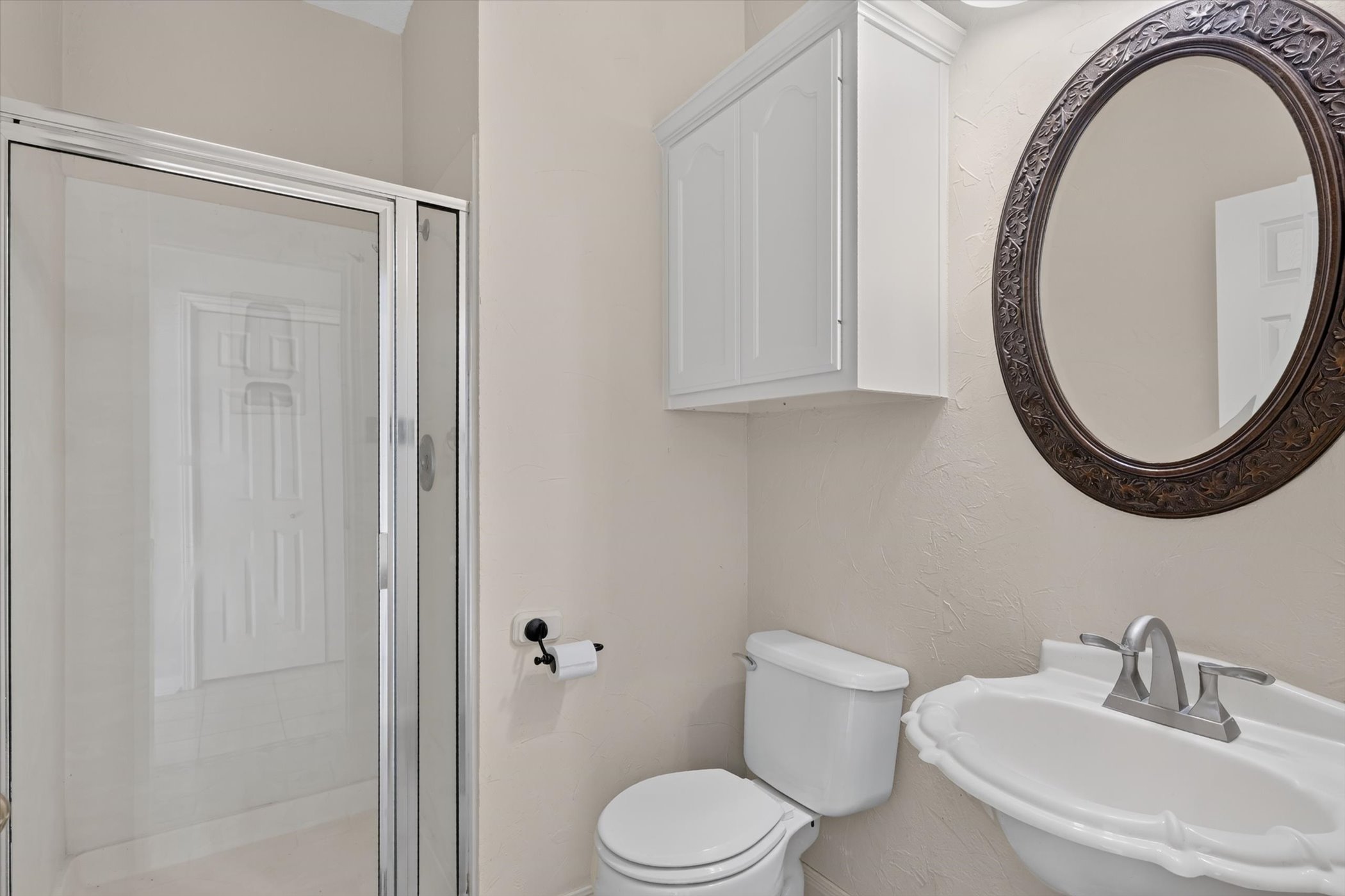 13615 Copperleaf Trail Manchaca, TX 78652 - Photo 18 of 38 Functional full bathroom featuring a stand-up shower, a toilet, and a sink with an ornate mirror.