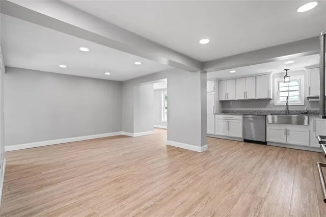 a kitchen with white cabinets stainless steel appliances and a window