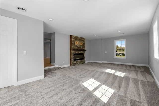 a view of empty room with fireplace and window