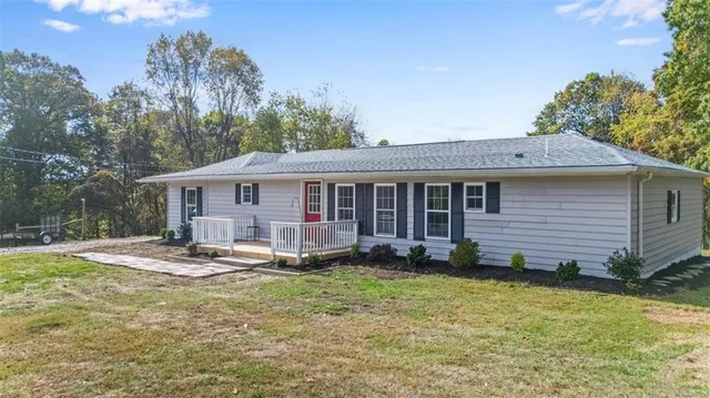 a view of a house with a yard and sitting area