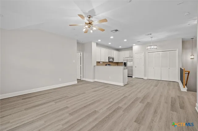 a view of a kitchen with a microwave and wooden floor