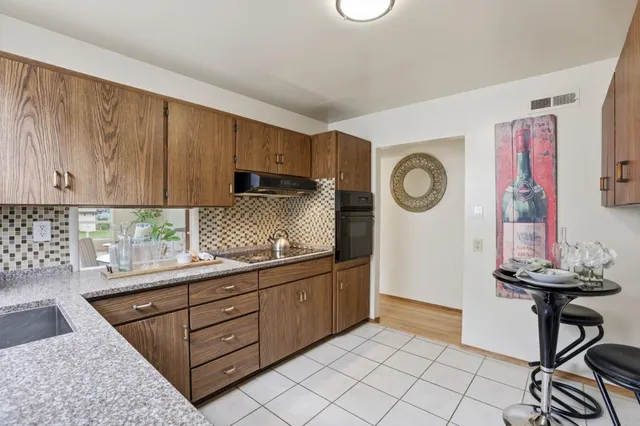 a kitchen with stainless steel appliances granite countertop a stove a sink and a cabinets