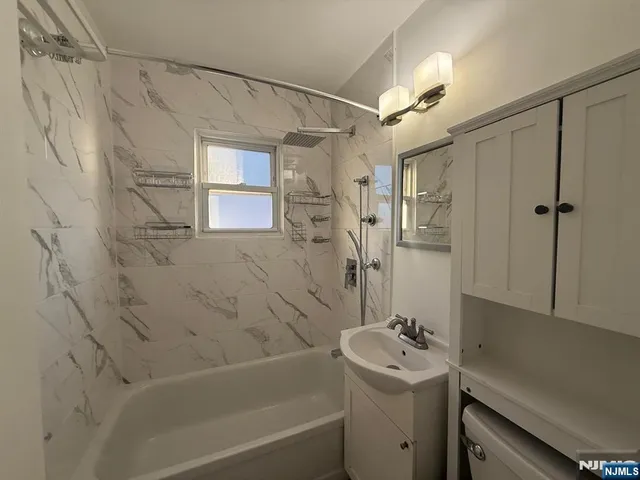 a bathroom with a sink mirror toilet and bathtub