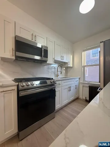 a kitchen with stainless steel appliances and white cabinets