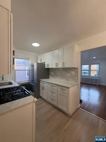 a kitchen with stainless steel appliances granite countertop a stove a sink and a refrigerator
