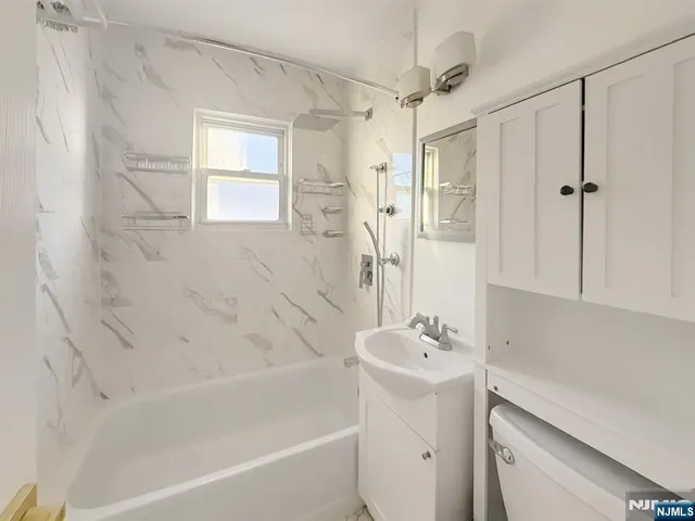 a bathroom with a sink a mirror toilet and bathtub