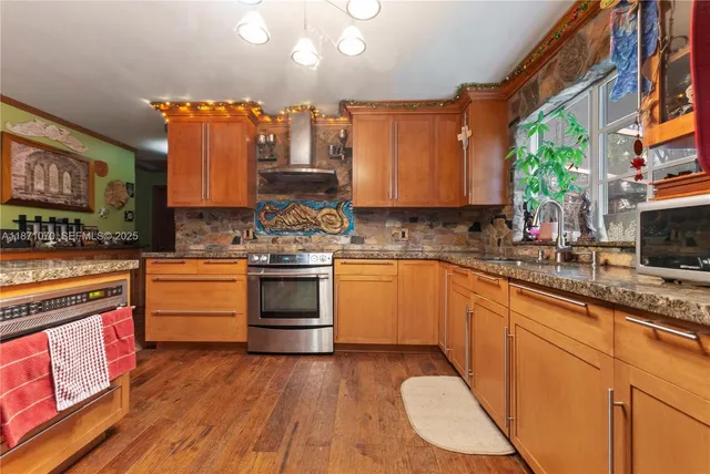 a kitchen with stainless steel appliances a stove a sink dishwasher and cabinets with wooden floor