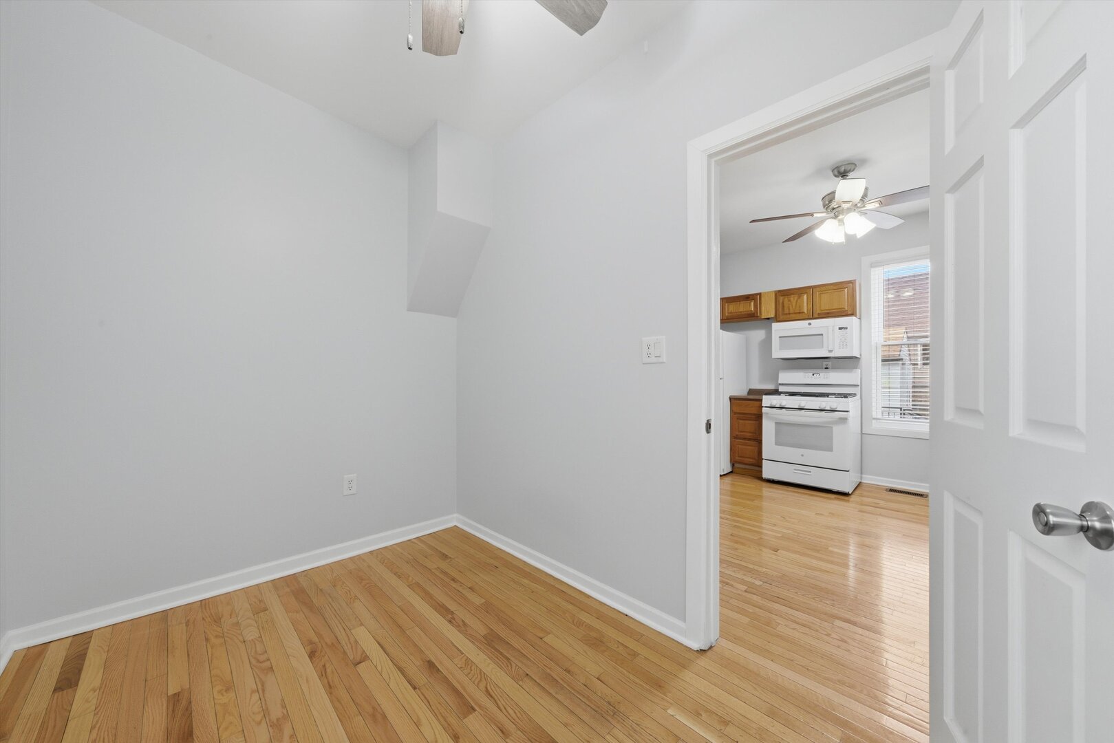 2125 West 18th Place, Unit 5 Chicago, IL 60608 - Photo 16 of 23 a view of a room with wooden floor and a ceiling fan