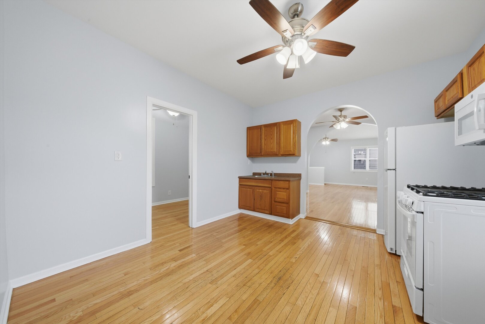2125 West 18th Place, Unit 5 Chicago, IL 60608 - Photo 6 of 23 a kitchen with stainless steel appliances a stove top oven a sink and a wooden floor