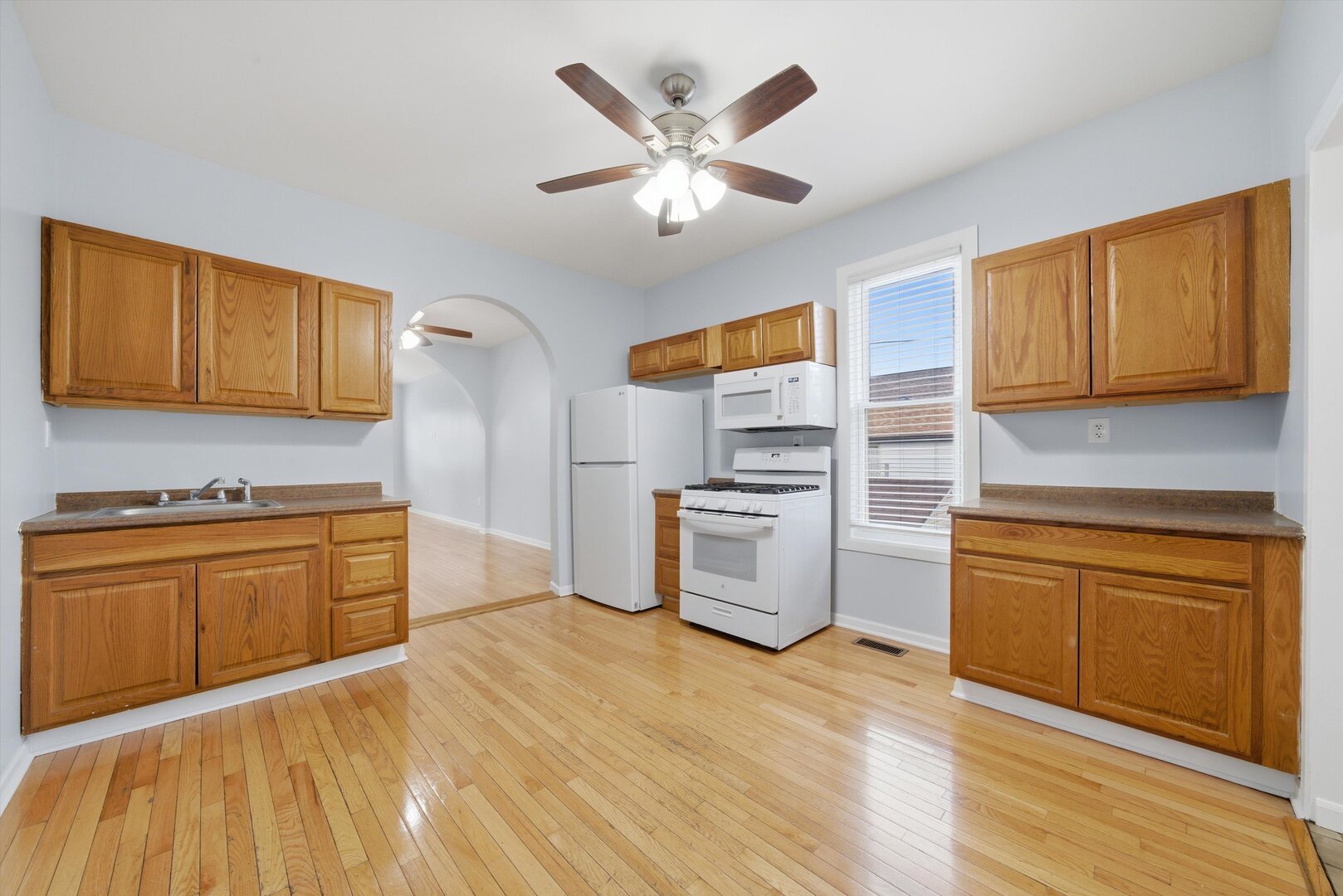 2125 West 18th Place, Unit 5 Chicago, IL 60608 - Photo 7 of 23 a kitchen with granite countertop a sink cabinets stainless steel appliances and a counter space