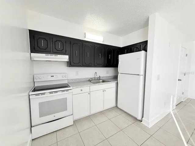 a kitchen with granite countertop cabinets and white appliances