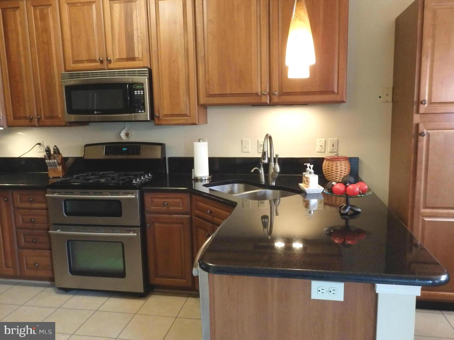 2236 Bear Den Road Frederick, MD 21701 - Photo 7 of 30 a kitchen with kitchen island granite countertop a sink stove and microwave