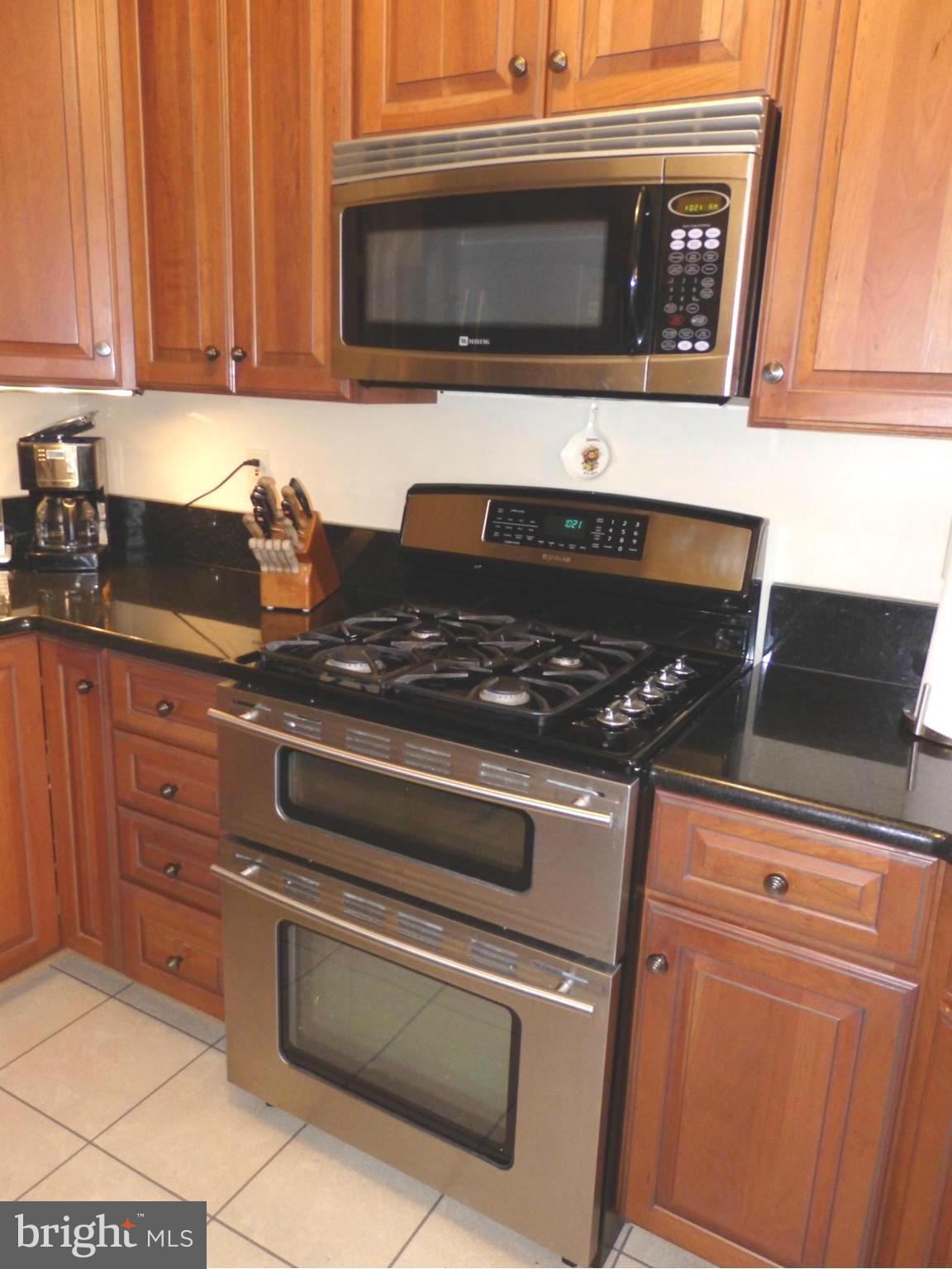 2236 Bear Den Road Frederick, MD 21701 - Photo 9 of 30 a kitchen with granite countertop a stove top oven microwave and cabinets