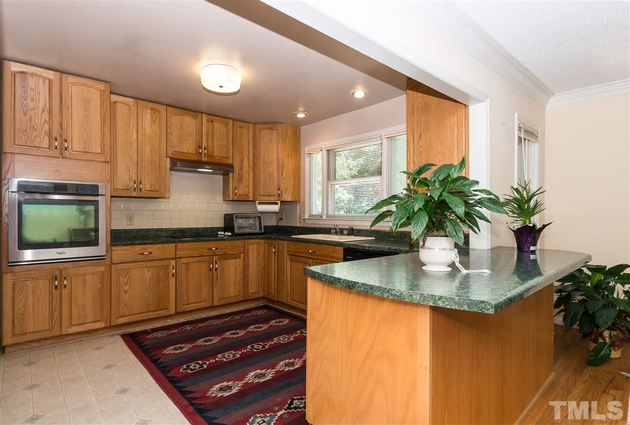 1926 Highland Place Raleigh, NC 27607 - Photo 5 of 23 a kitchen with kitchen island granite countertop a sink a stove and cabinets