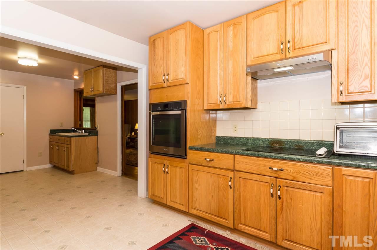 1926 Highland Place Raleigh, NC 27607 - Photo 6 of 23 a kitchen with granite countertop white cabinets and stainless steel appliances