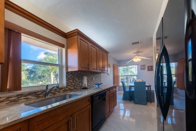 a kitchen with stainless steel appliances granite countertop a sink a stove and a refrigerator