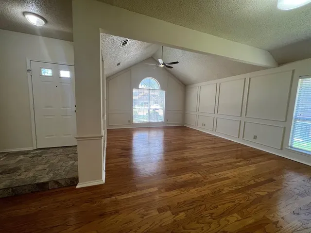 a view of a room with wooden floor and a window