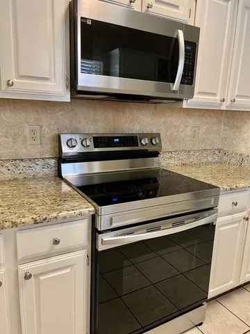 a stove top oven sitting inside of a kitchen