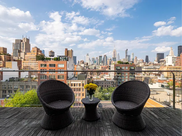 a view of a balcony with two chairs and a potted plant