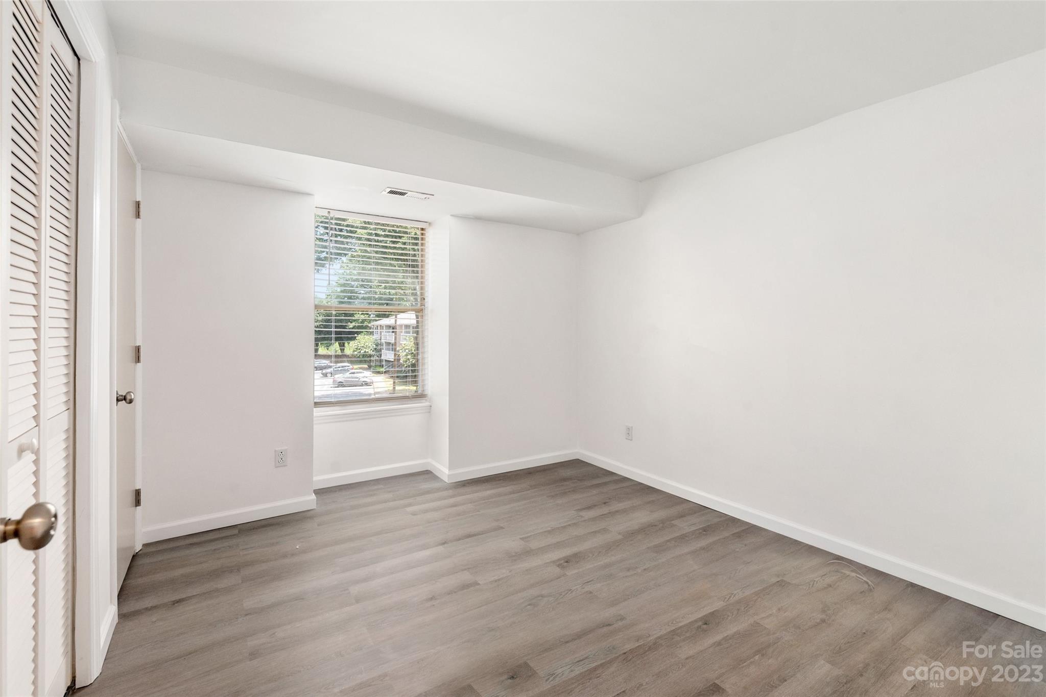 9333 Old Concord Road, Unit J Charlotte, NC 28213 - Photo 14 of 17 an empty room with wooden floor and a window