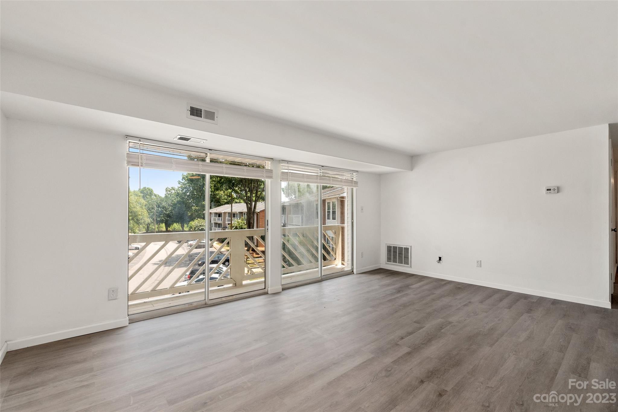 9333 Old Concord Road, Unit J Charlotte, NC 28213 - Photo 3 of 17 an empty room with wooden floor and windows